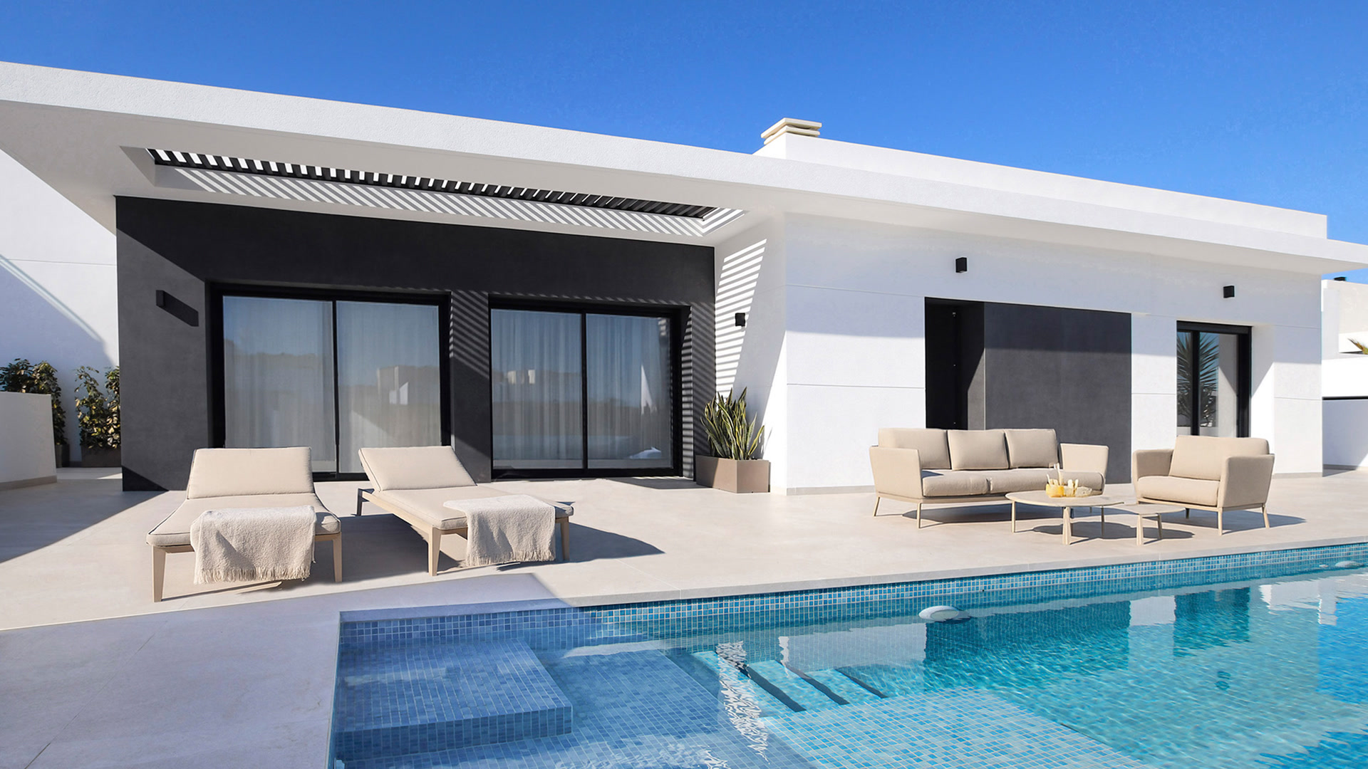 Pool with seating area in front of the villa